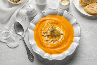 Photo of Flat lay composition with bowl of pumpkin soup on table