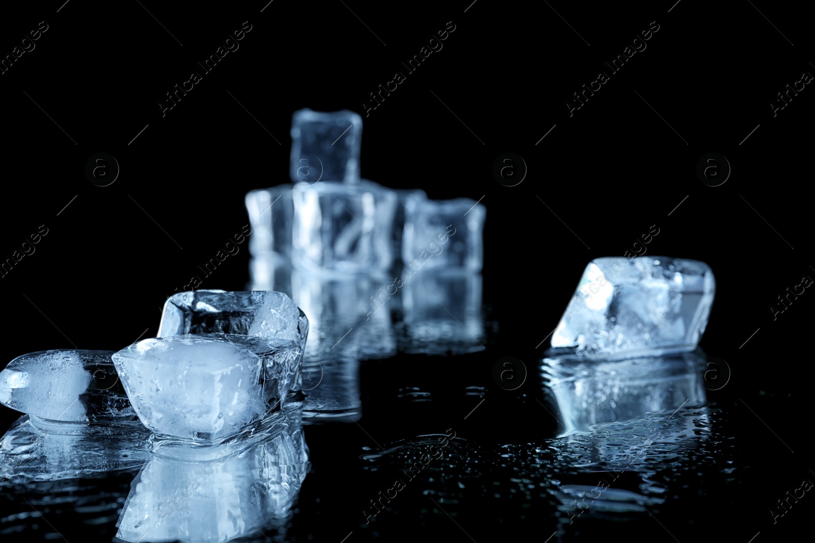 Photo of Ice cubes on black mirror surface. Space for text