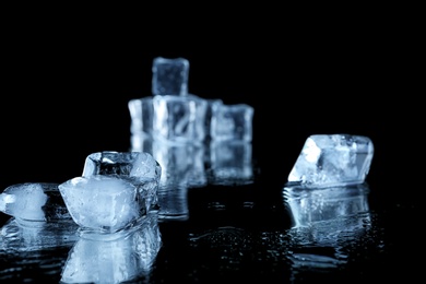 Photo of Ice cubes on black mirror surface. Space for text