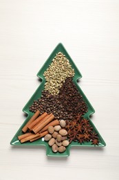 Different spices and nuts on white wooden table, top view