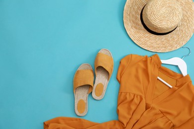 Photo of Dress, straw hat and shoes on light blue background, flat lay with space for text. Clothes rent concept