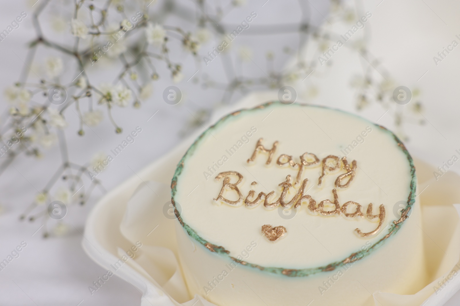 Photo of Delicious decorated Birthday cake near dry flowers on white cloth, closeup