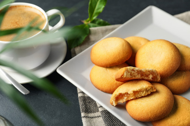 Photo of Tasty shortbread cookies with filling on black table, closeup
