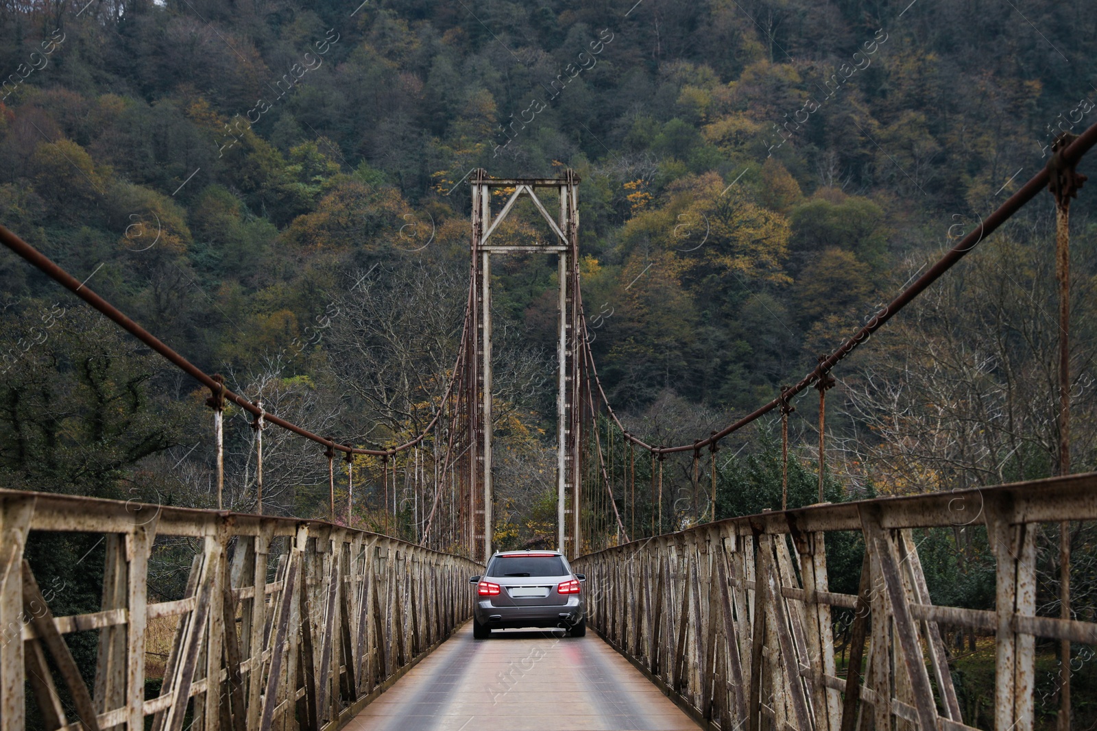 Photo of Beautiful view on rusty metal bridge with car in mountains