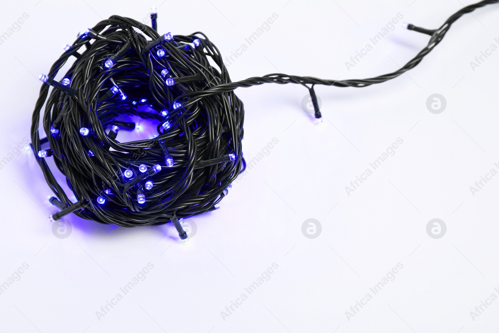 Photo of Beautiful Christmas lights on white background, top view