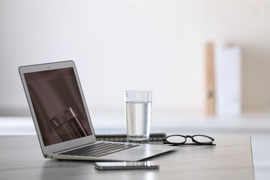 Modern workplace with laptop on grey table in office