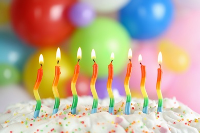 Photo of Birthday cake with burning candles on blurred background, closeup