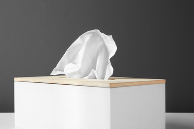 Photo of Holder with paper tissues on table, closeup