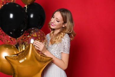 Photo of Happy woman with air balloons on red background, space for text. Christmas party
