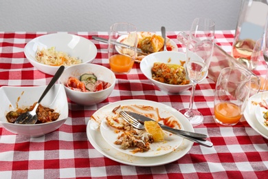 Photo of Food leftovers after party on table with checkered cloth