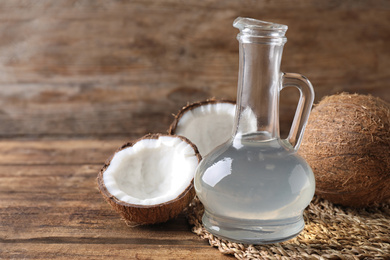 Photo of Composition with coconut oil on wooden table, space for text