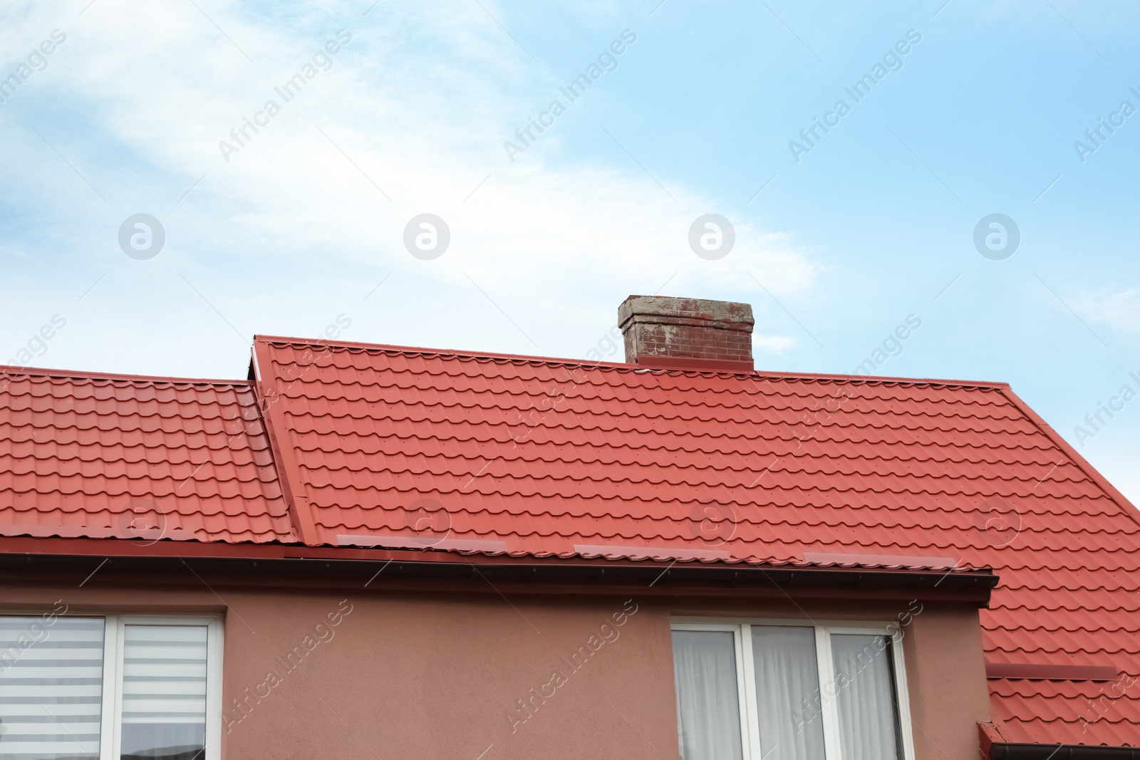 Photo of Beautiful house with red roof against blue sky