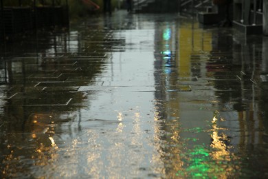 Photo of Pavement with puddles on city street after rain