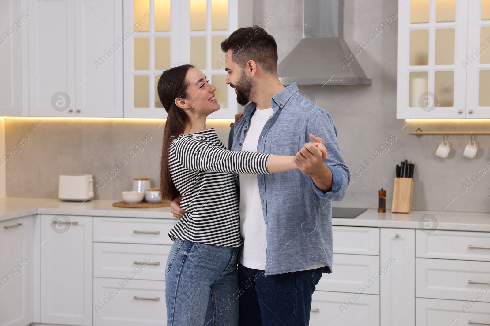 Photo of Happy lovely couple dancing together in kitchen