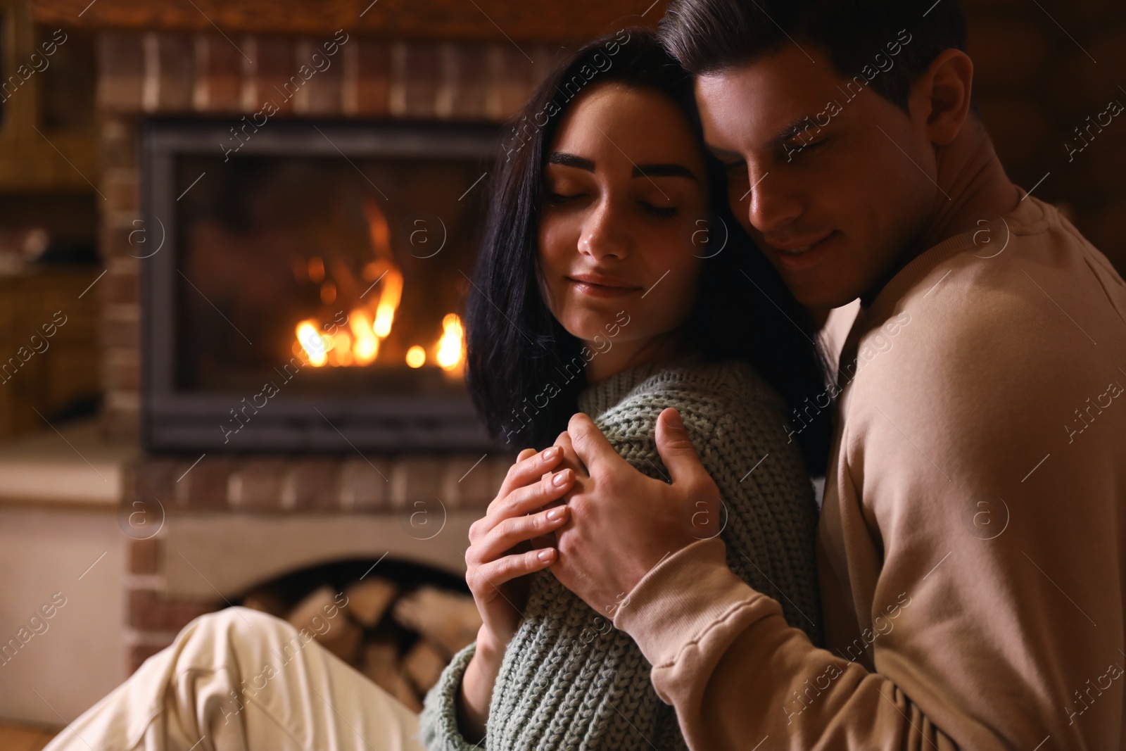 Photo of Lovely couple near fireplace at home. Winter vacation