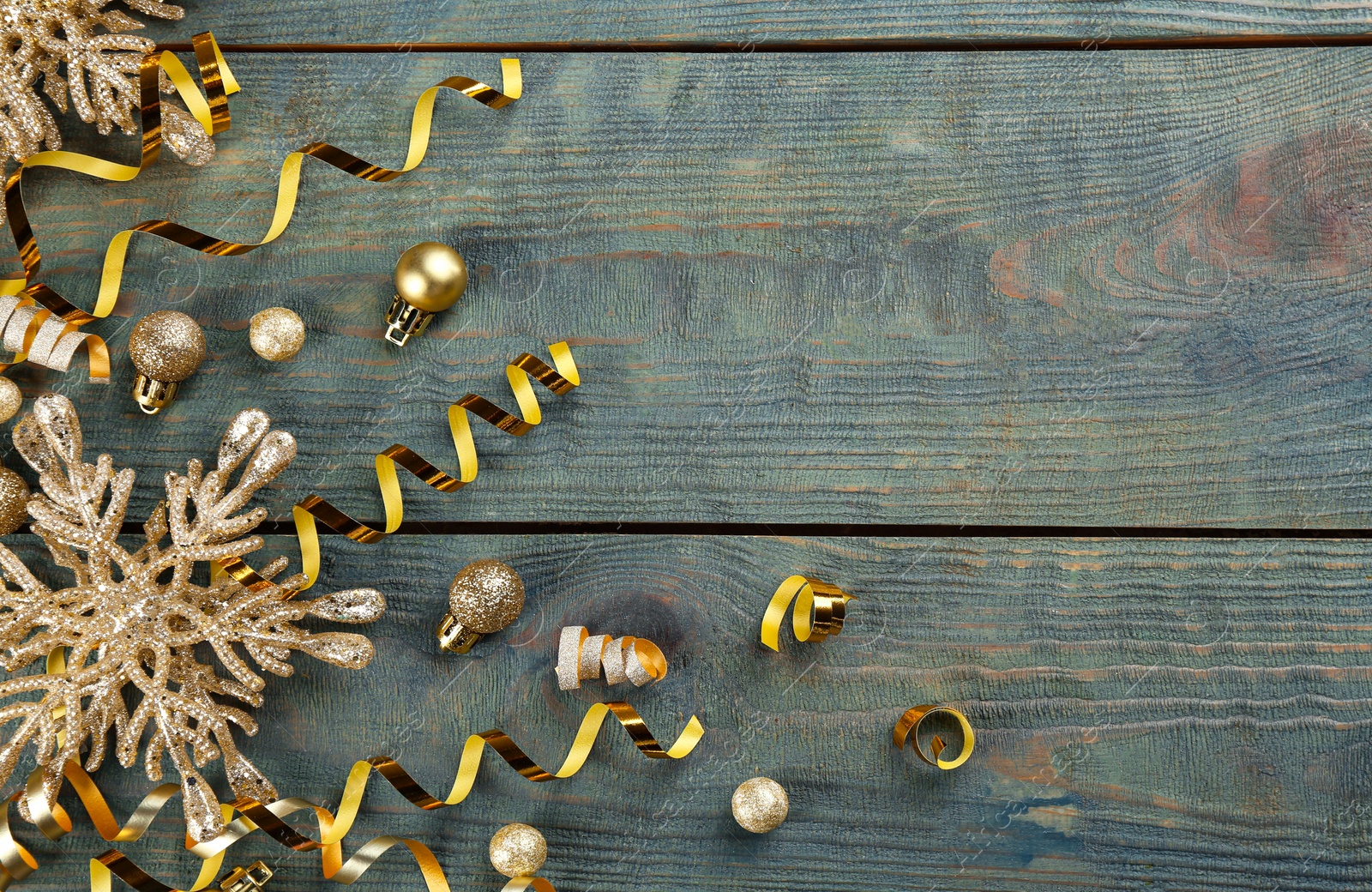 Photo of Flat lay composition with serpentine streamers and Christmas decor on blue wooden background. Space for text