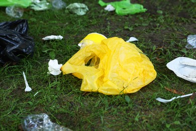 Photo of Different garbage scattered on green grass outdoors