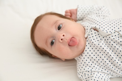 Photo of Portrait of adorable baby on white sheet