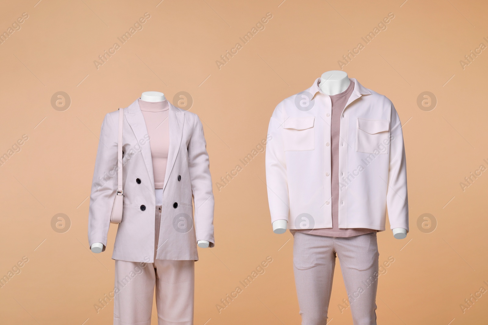 Photo of Male and female mannequins dressed in stylish outfits on beige background