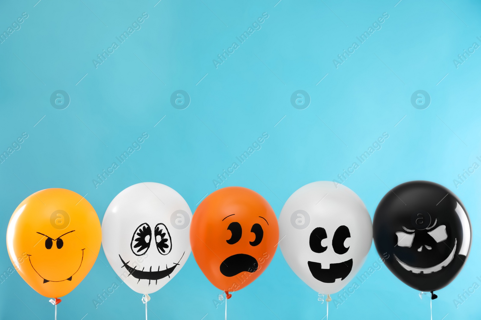 Photo of Spooky balloons for Halloween party on blue background, space for text
