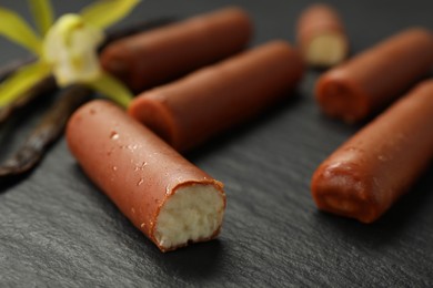 Photo of Glazed curd cheese bars on black table, closeup