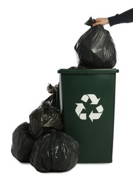 Photo of Man putting garbage bag into recycling bin on white background, closeup