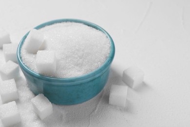 Different types of sugar in bowl on white table, closeup. Space for text