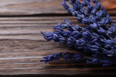 Photo of Bouquet of beautiful preserved lavender flowers on wooden table, closeup. Space for text
