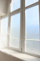 Photo of Window covered with polyethylene film. Protection during repair