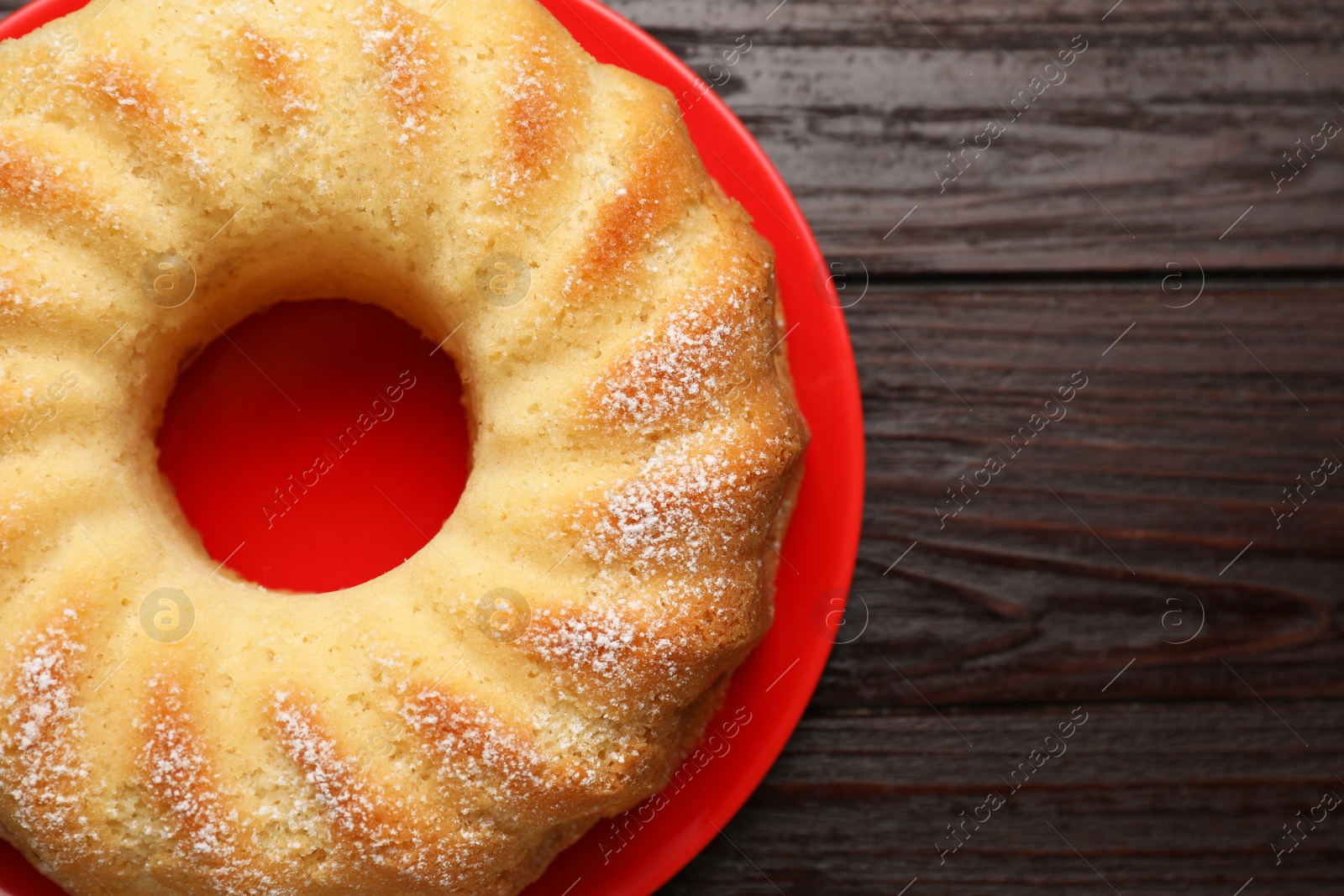 Photo of Delicious freshly baked sponge cake on wooden table, top view. Space for text