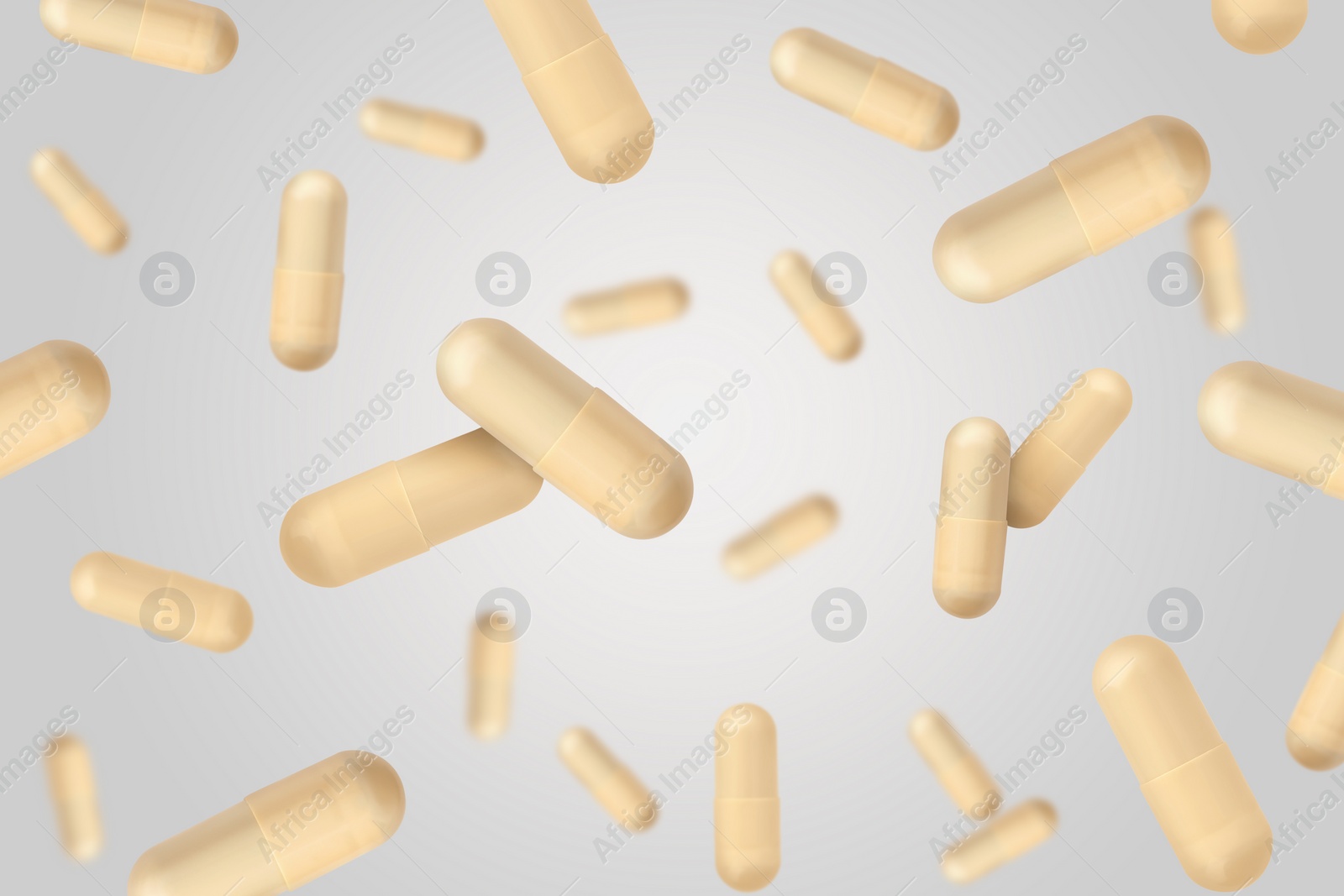 Image of Vitamin. Capsules falling on light grey background