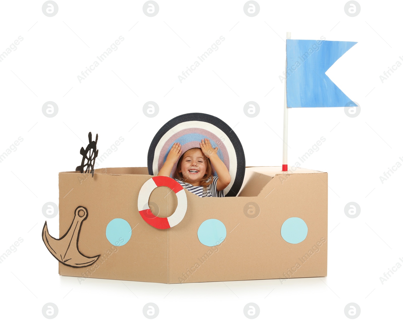 Photo of Cute little girl playing with cardboard ship on white background