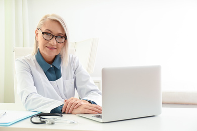 Photo of Portrait of mature female doctor in white coat at workplace