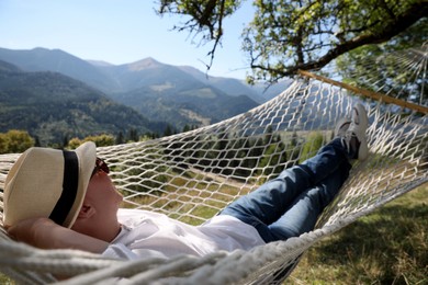 Young man resting in hammock outdoors on sunny day