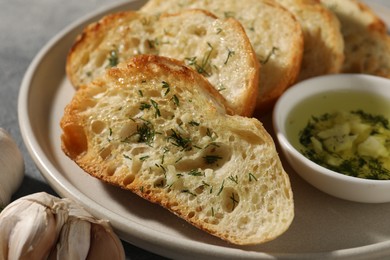 Photo of Tasty baguette with garlic, oil and dill on table, closeup