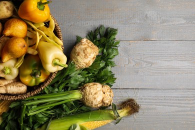 Different fresh ripe vegetables and fruits on grey wooden table, flat lay. Space for text