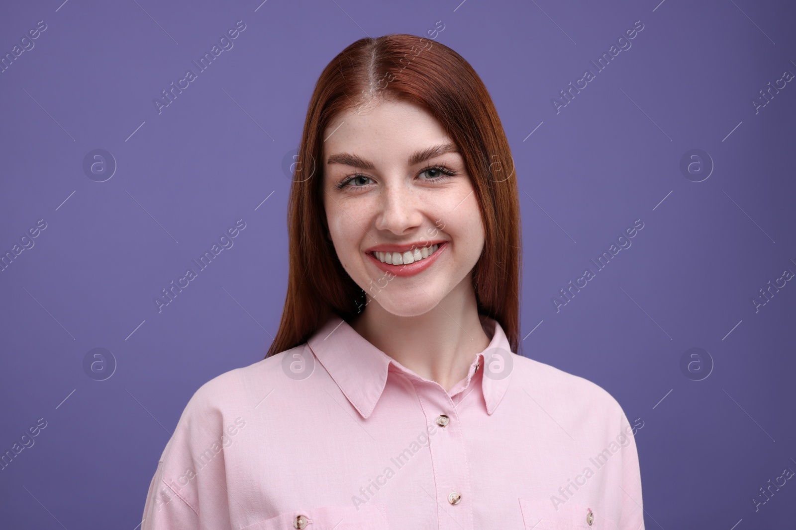 Photo of Portrait of smiling woman with freckles on purple background