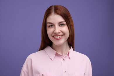 Portrait of smiling woman with freckles on purple background