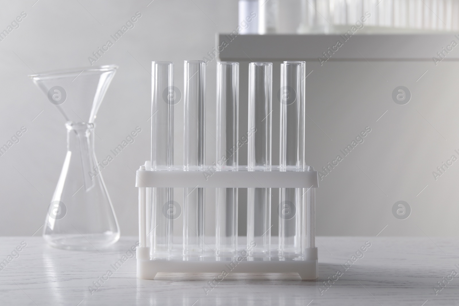 Photo of Set of laboratory glassware on white wooden table indoors