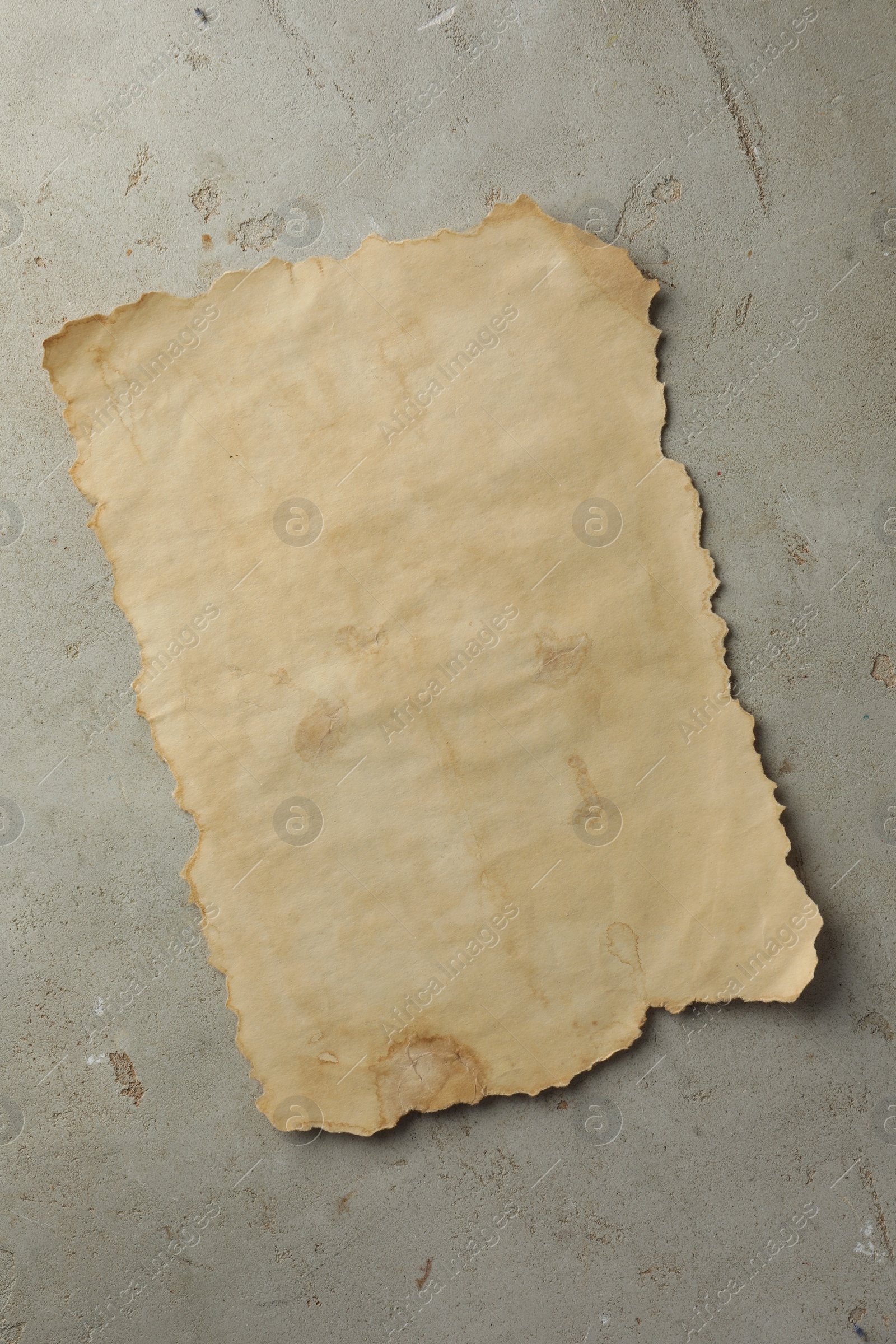 Photo of Sheet of old parchment paper on grey table, top view