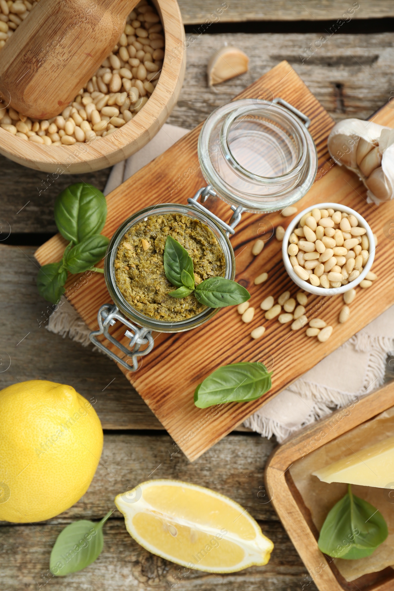 Photo of Delicious pesto sauce and ingredients on wooden table, flat lay