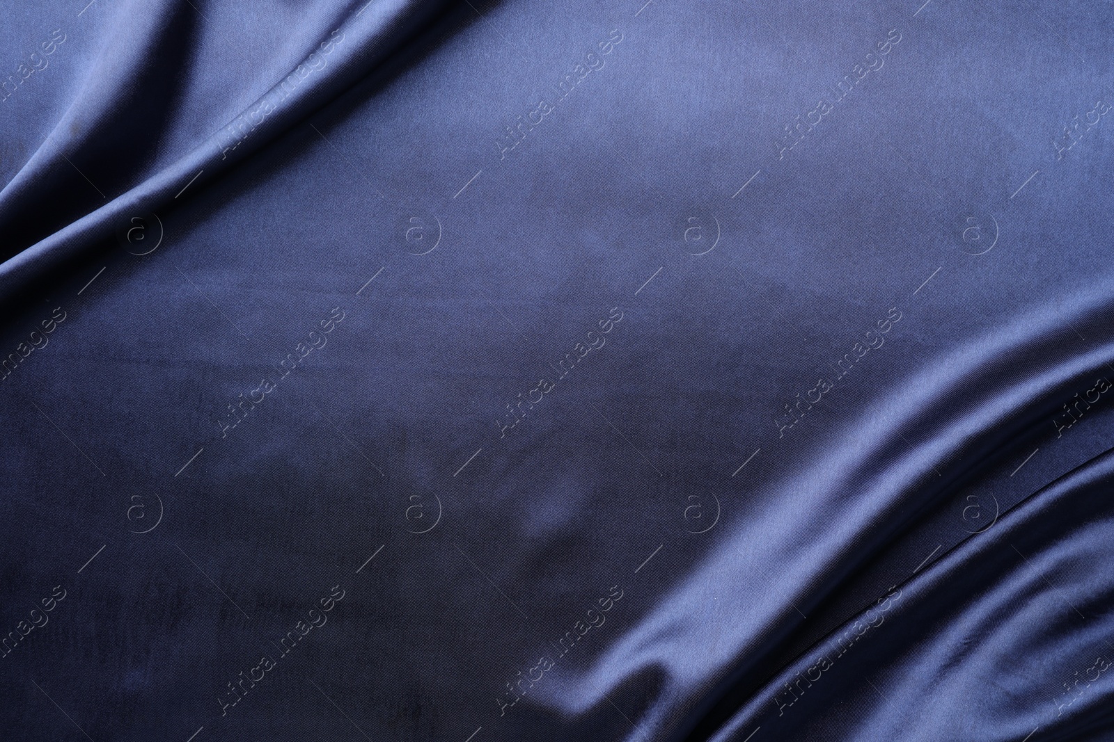 Photo of Crumpled dark blue silk fabric as background, top view. Space for text