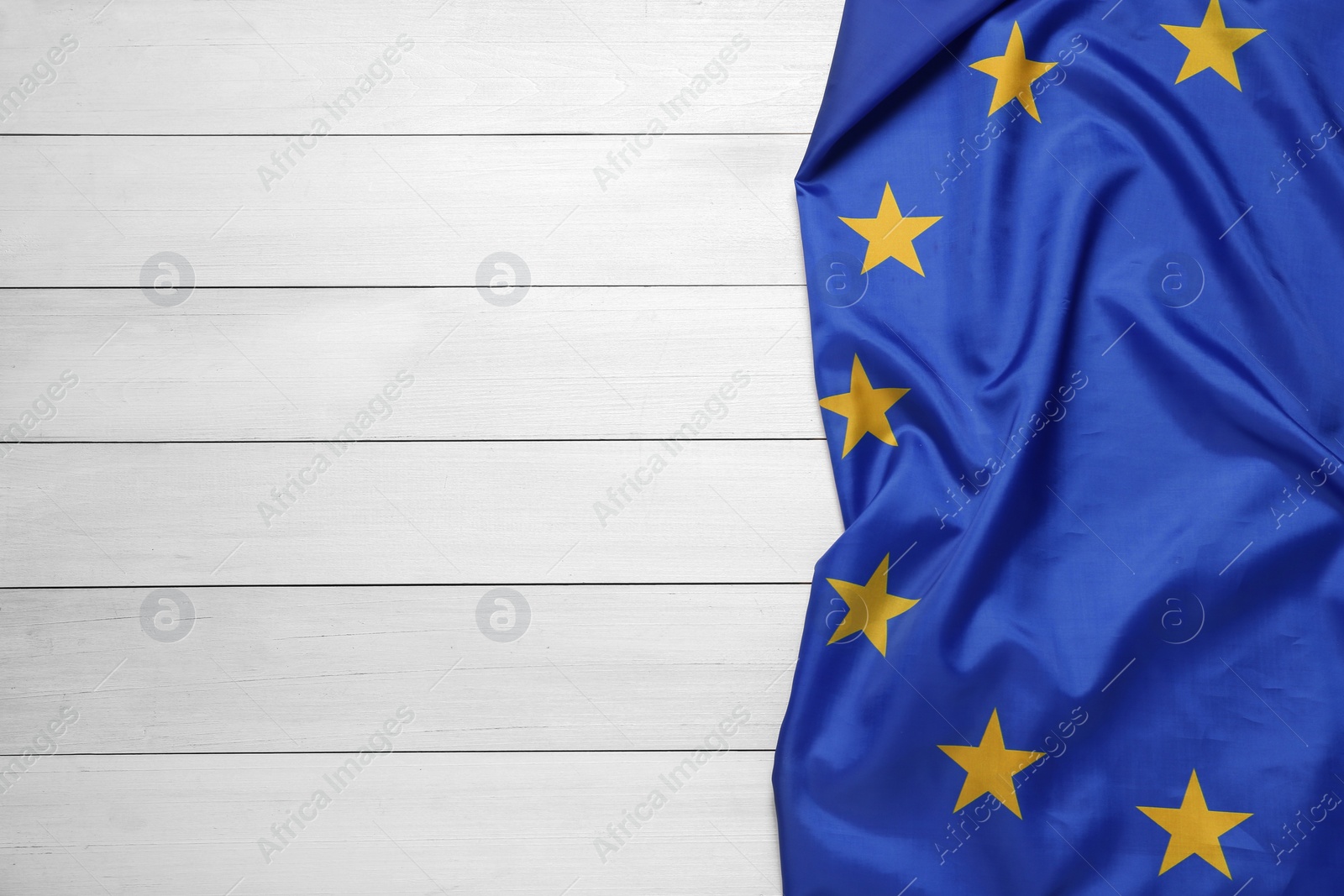 Photo of Flag of European Union on white wooden background, top view. Space for text