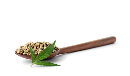 Photo of Spoon with hemp seeds and green leaf on white background