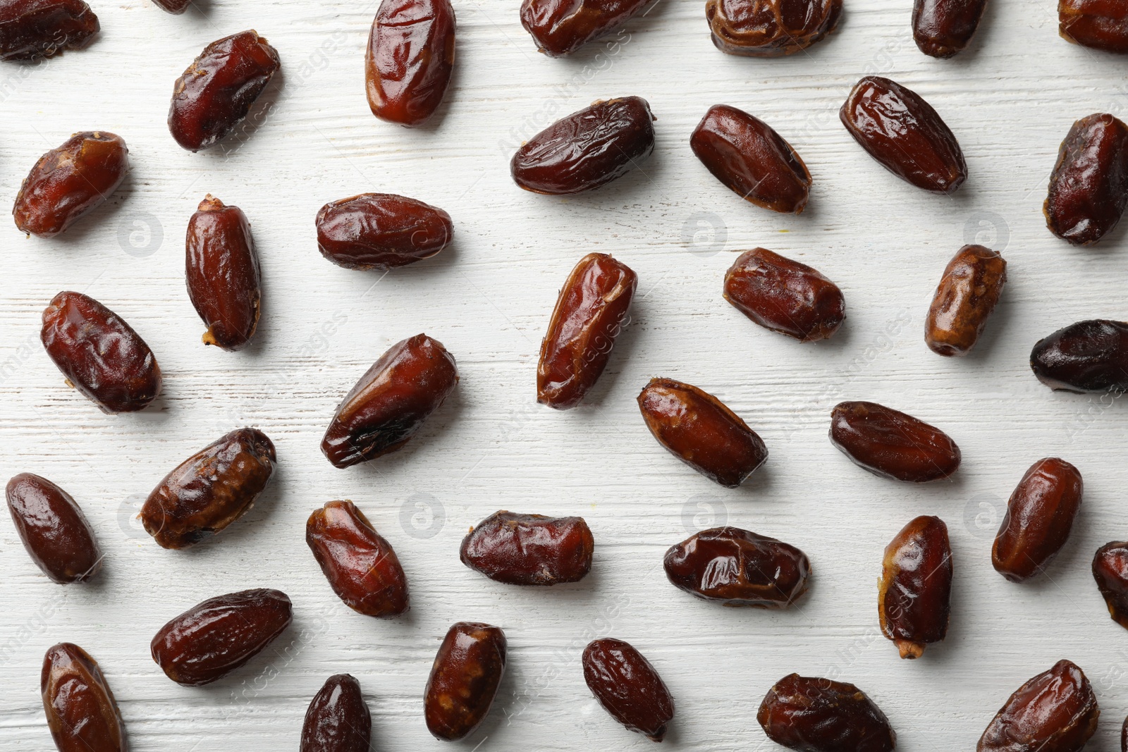 Photo of Flat lay composition with dates on wooden background. Dried fruit as healthy snack