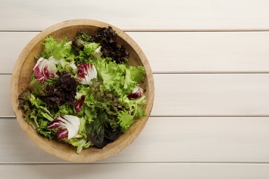 Photo of Different sorts of lettuce on white wooden table, top view. Space for text