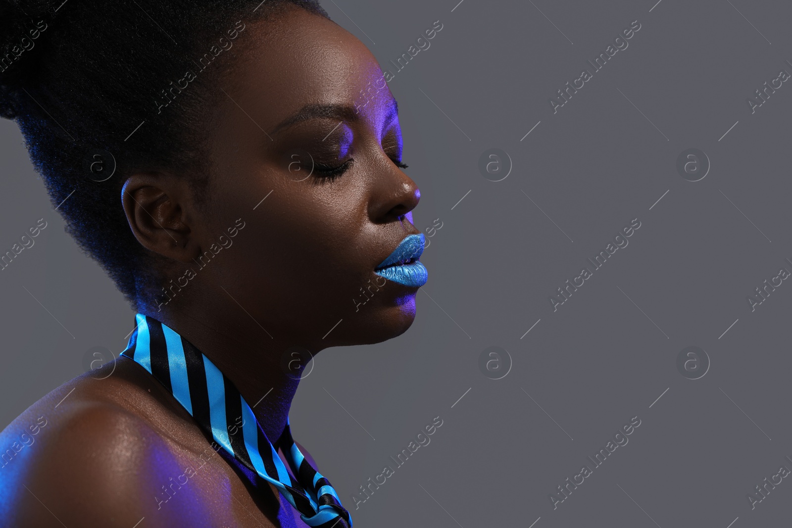 Photo of Fashionable portrait of beautiful woman with bright makeup on grey background, space for text