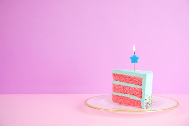 Photo of Slice of fresh delicious birthday cake with candle on table against color background. Space for text