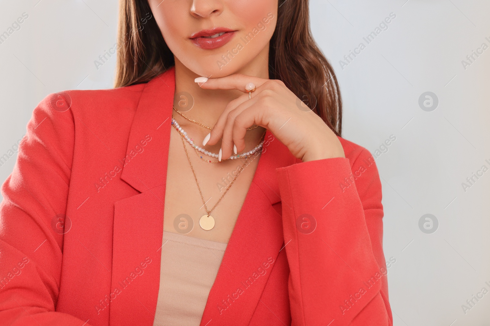 Photo of Beautiful woman with elegant jewelry on light background, closeup