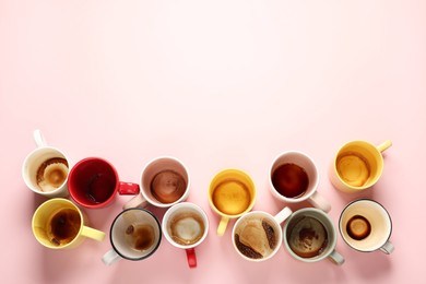 Many dirty cups after drinking coffee on pink table, flat lay. Space for text
